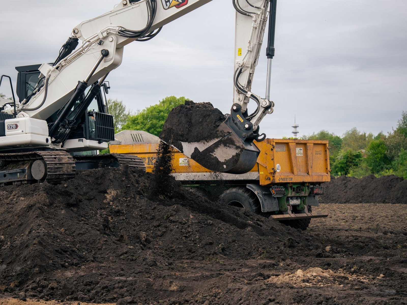 CAT 320 Kettenbagger beim Verladen eines Kippers